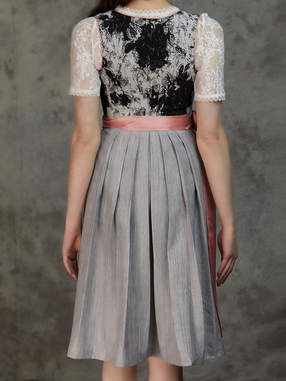 Ein elegantes schwarzes Ehreer Dirndl mit weißer Schürze und Spitzenbluse
